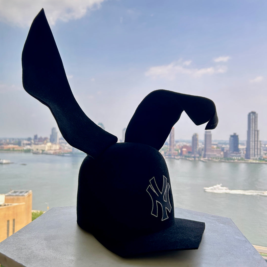 Khia Tullae The 212 Asymmetric Bunny Lid hat in black felt with New York logo and bendable ears, front angled right view with bent ear