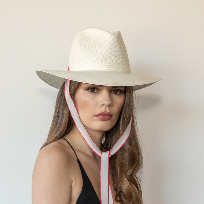 Khia Tullae The Morgan white toquilla straw wide-brim hat with red and white drop-down silk ribbon tied under chin, front view on model