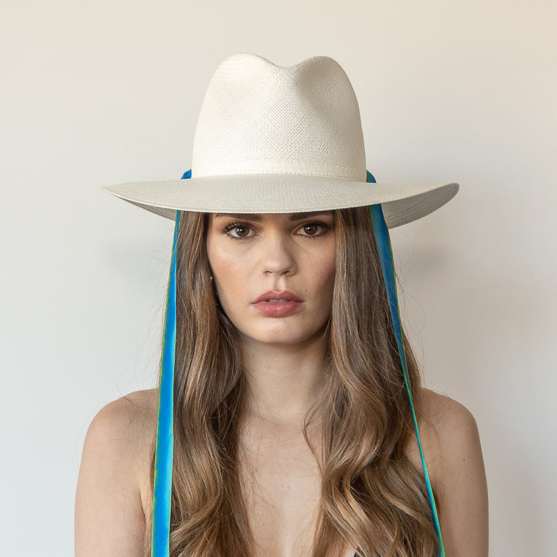 Khia Tullae The Amani white toquilla straw wide-brim hat with blue and green drop-down silk ribbon ties, front view on model
