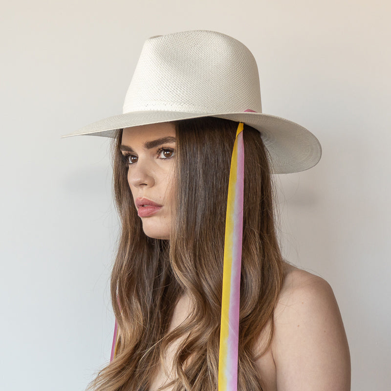 Khia Tullae The Bailey white toquilla straw wide-brim hat with yellow and pink drop-down silk ribbon ties, side view on model