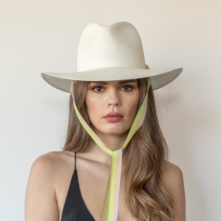 Khia Tullae The Harlow white toquilla straw wide-brim hat with neon green and pastel pink drop-down silk ribbon tied under chin, front view on model