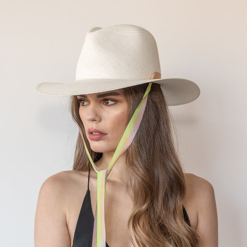 Khia Tullae The Harlow white toquilla straw wide-brim hat with neon green and pastel pink drop-down silk ribbon tied under chin, side view on model