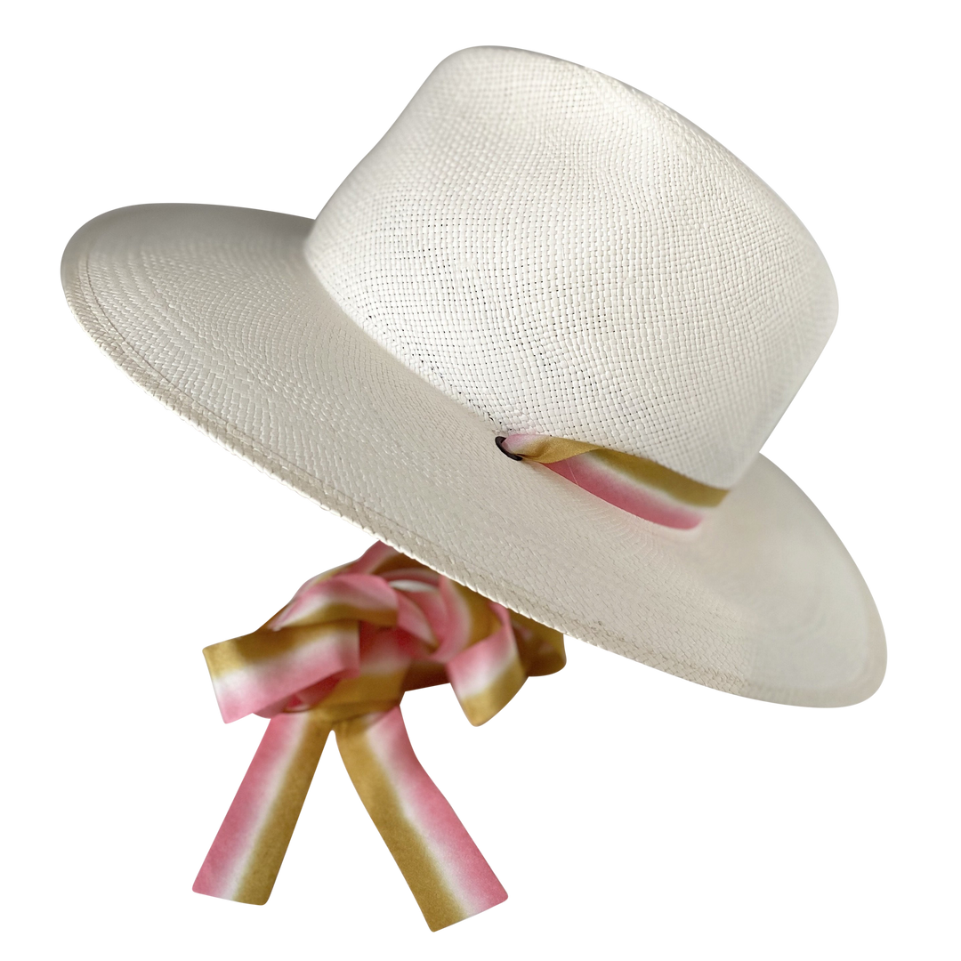 Khia Tullae The Margaux white toquilla straw wide-brim hat with golden caramel and pastel pink silk drop-down ribbon, angled product cutout with ribbon detail