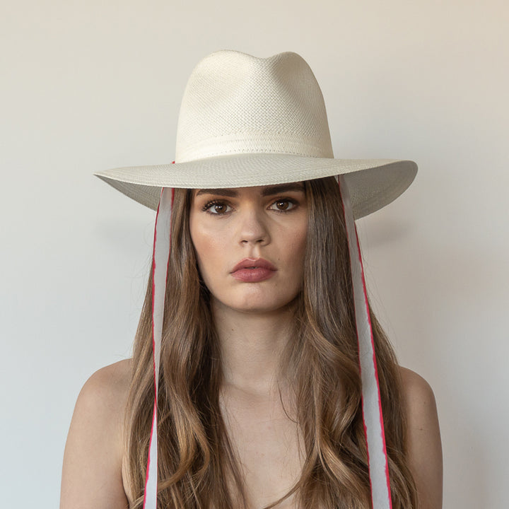 Khia Tullae The Morgan white toquilla straw wide-brim hat with red and white drop-down silk ribbon ties, front view on model
